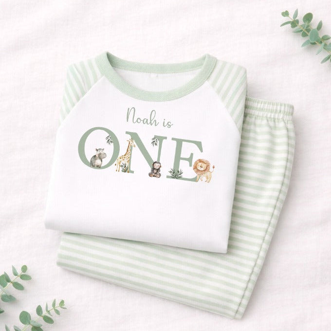 Children's outfit with 'Noah is ONE' text and animal illustrations on a white background.